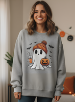 Woman wearing a gray sweatshirt with a Halloween-themed ghost design in a room decorated for the holiday.