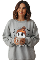 Woman wearing a gray sweatshirt with a ghost character holding a mug, on a white background