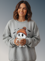 Woman wearing a gray sweatshirt with a ghost design, holding a mug against a gradient background