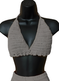 Gray crochet top on a black mannequin against a white background