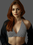 Woman wearing a gray bralette with a dark jacket on a gray background