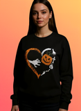 Person wearing a black sweatshirt with Halloween-themed design on an orange background