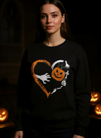 Person wearing a black Halloween-themed sweatshirt with pumpkins and ghosts in a heart shape.