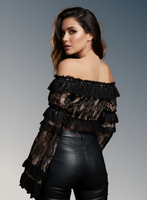 Woman wearing a black off-shoulder top and leather pants against a gray background