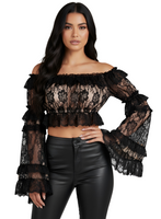 Woman wearing a black lace top and leather pants on a white background