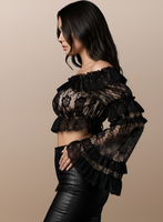 Black lace top worn by a model on a beige background