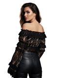 Woman wearing a black off-shoulder top with ruffles and black leather pants on a white background