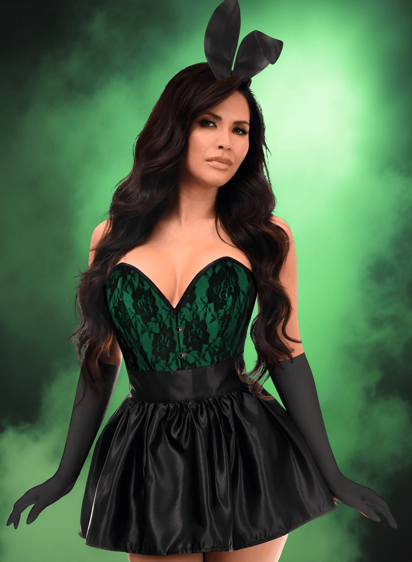 Woman in a green and black dress with bunny ears against a green background